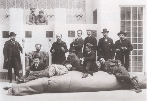 Members of the Vienna Secession at the group's 14<sup>th</sup> (“Beethoven”) Exhibition (1902). Left to right: Anton Stark, Gustav Klimt (in the chair), Koloman Moser (before Klimt with hat) Adolf Böhm, Maximilian Lenz (lying), Ernst Stöhr (with hat), Wilhelm List, Emil Orlik (seated), Maximilian Kurzweil (with cap), Leopold Stolba, Carl Moll (horizontal), Rudolf Bacher