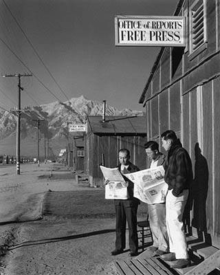 Roy Takeno, Editor, and Group Reading Paper in Front of Office, Manzanar Relocation Center, California (1943)